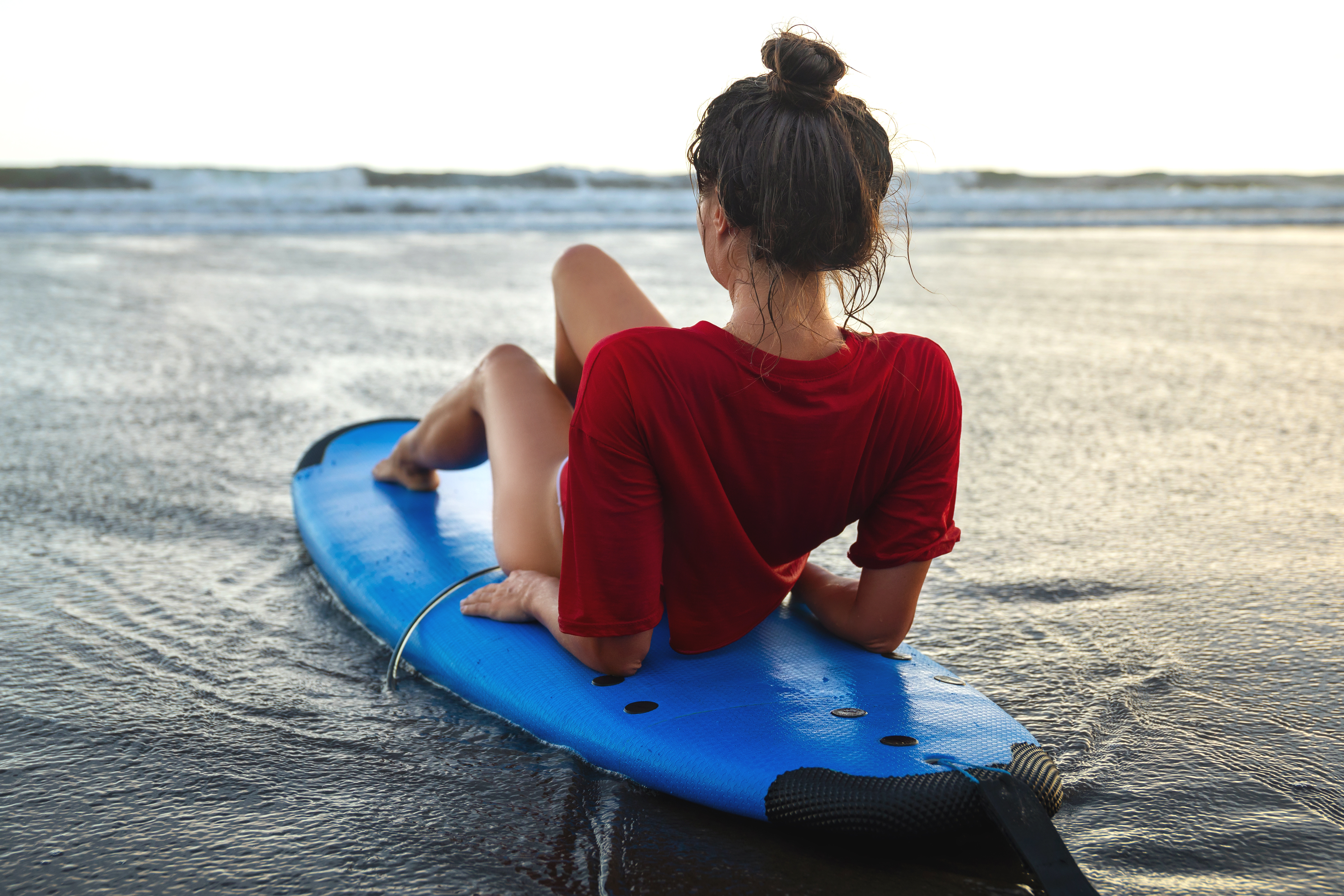 woman-sitting-on-surfboard-on-the-beach-after-her-2023-11-27-05-26-30-utc